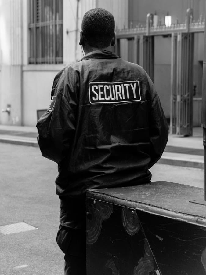 Black-and-white photo of a security guard seen from behind
